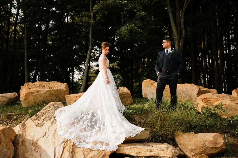 Wedding couple outdoors amid boulders.