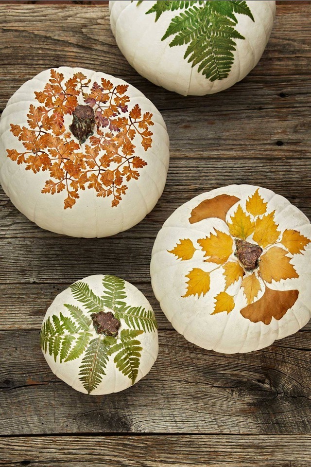 Glazed ceramic pumpkins with fall leaf designs.
