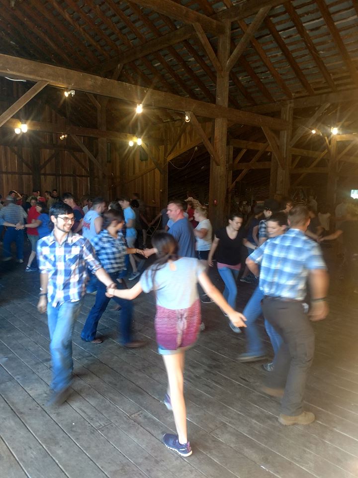 People square dancing in barn.